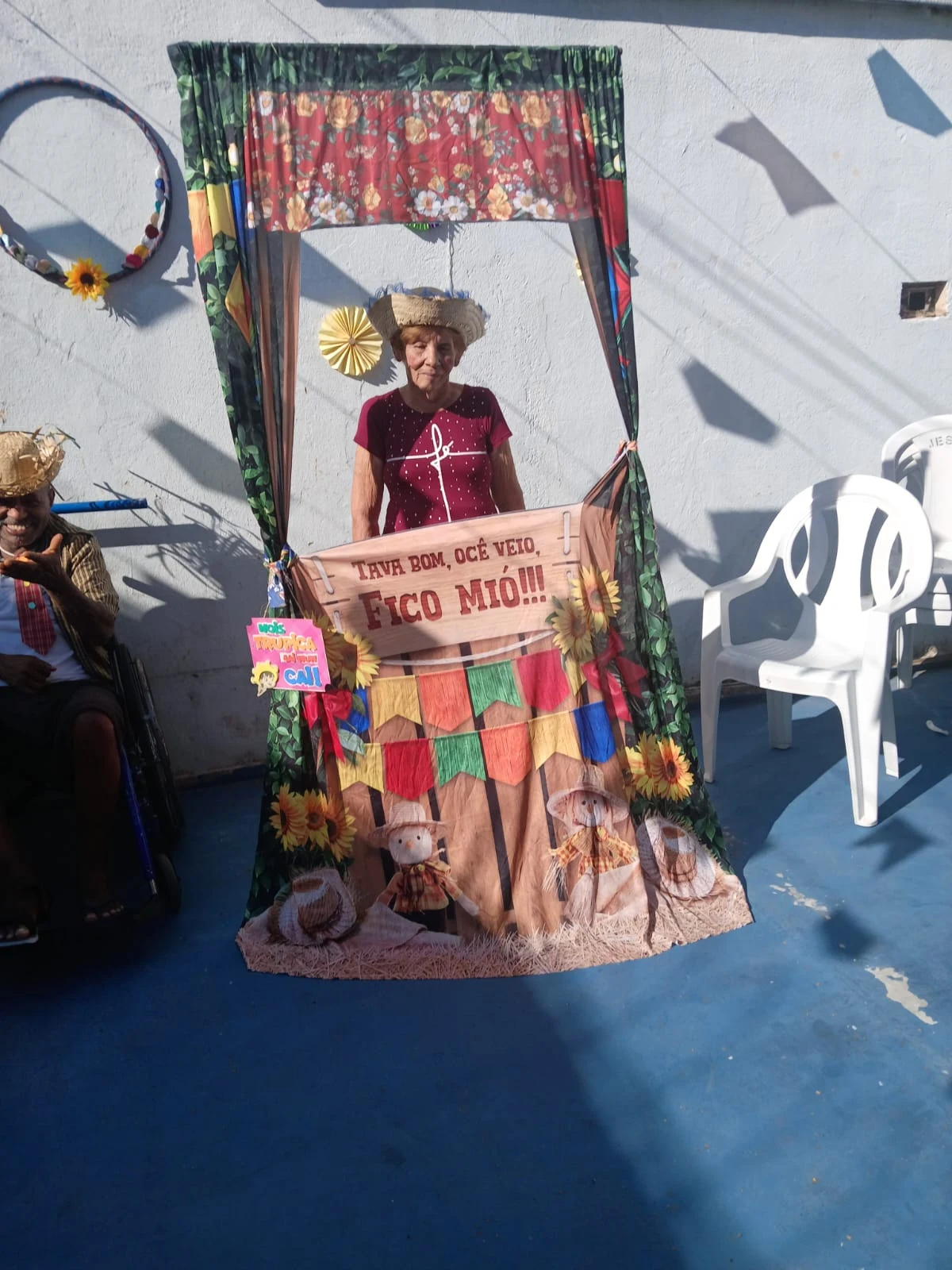 Residente junto ao painel de fotografias da festa junina