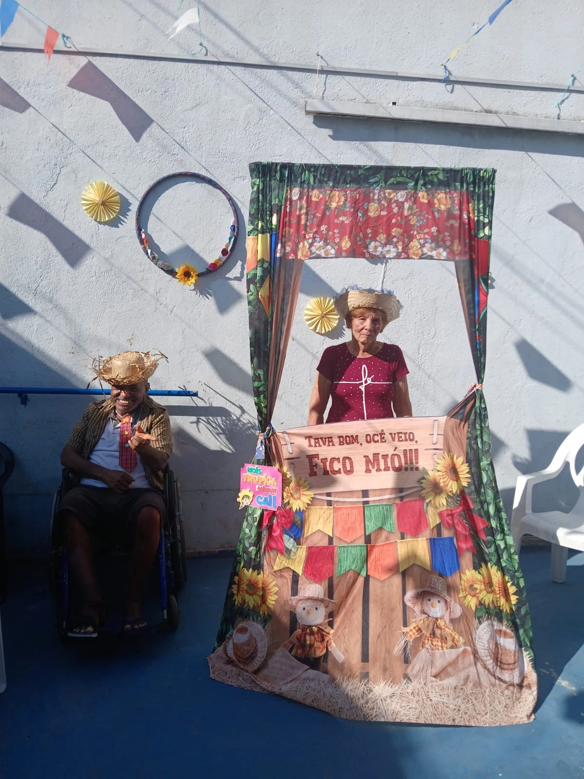 Residentes junto ao cenário de fotografias da festa junina