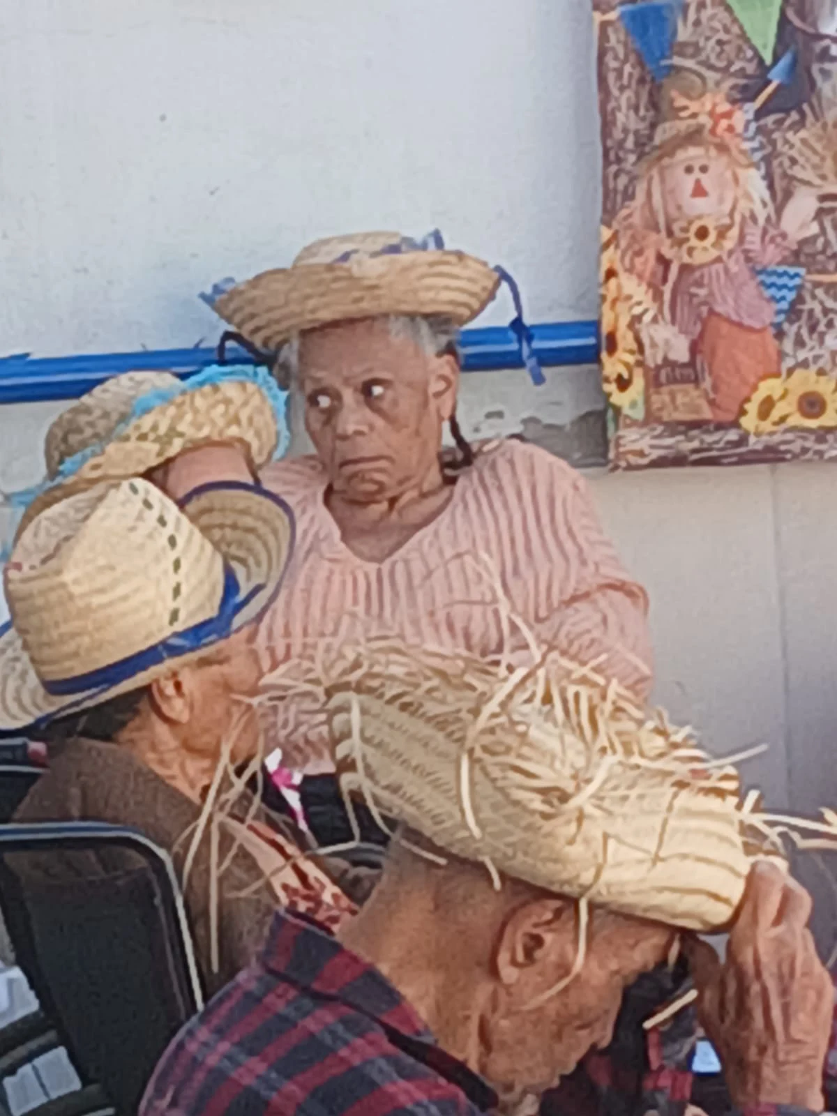 Residentes conversando com chapéus de palha na celebração
