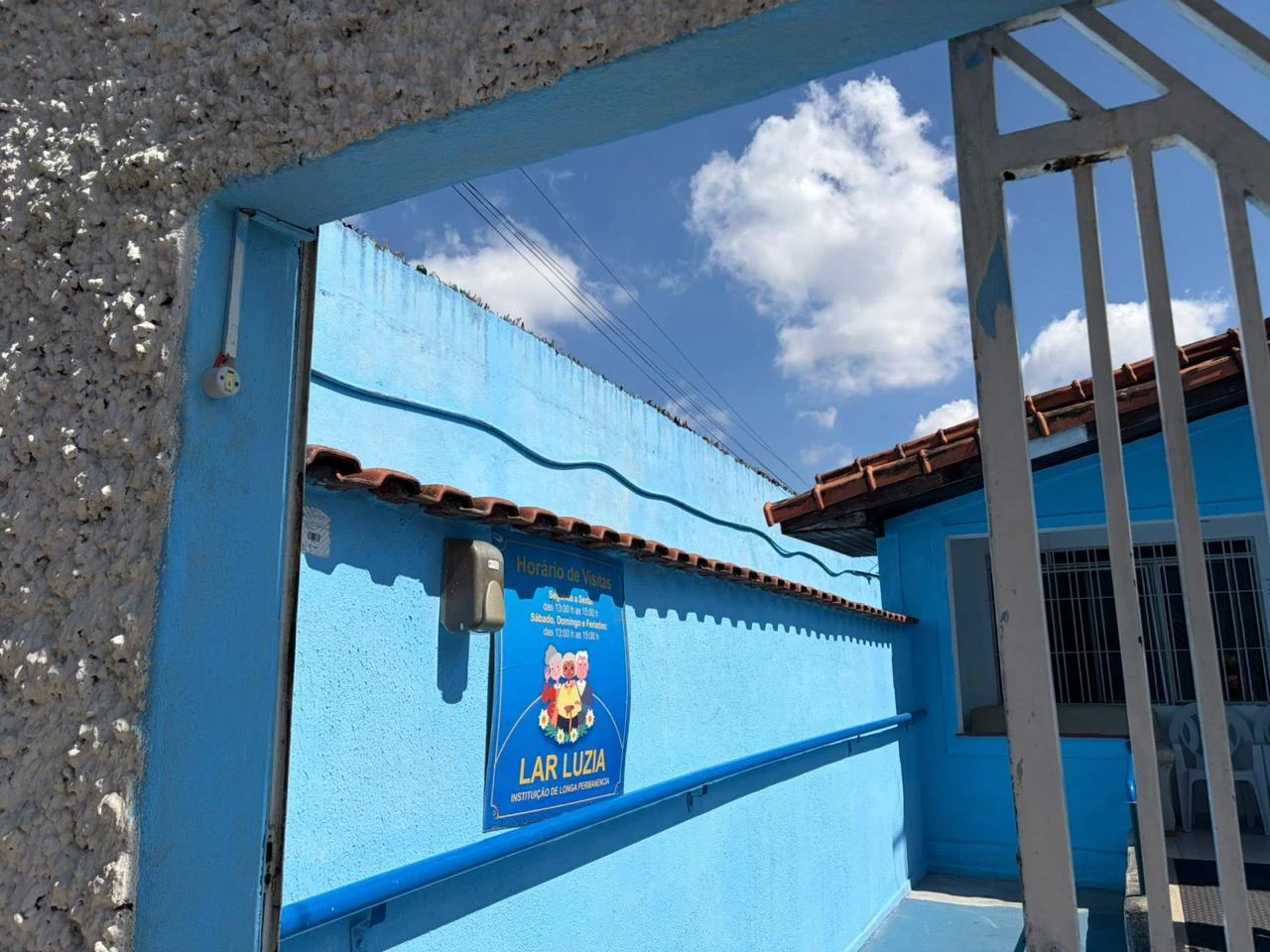 Entrada do Lar Luzia com identificação na fachada azul